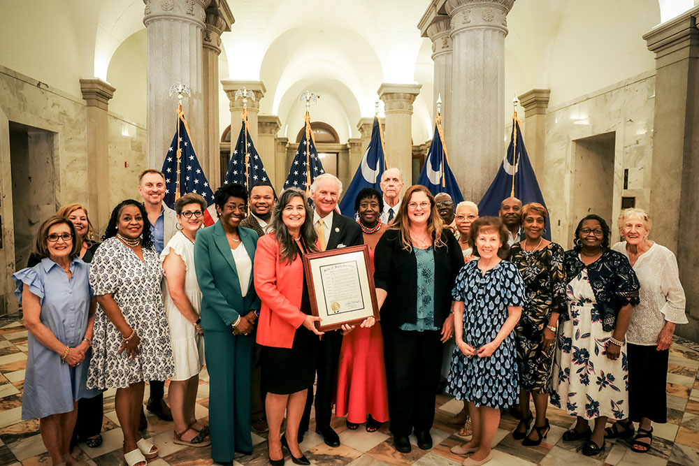 Surrounded by members of the Foster Care Review Board, Governor McMaster and Director Whittle hold the framed proclamation